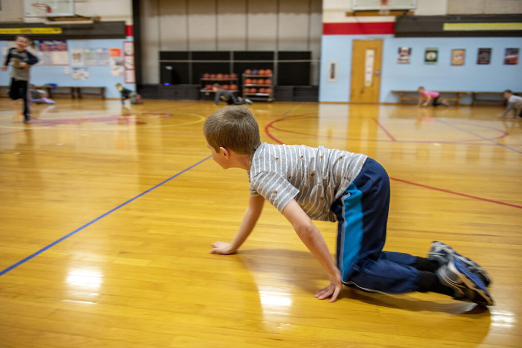 An elementary student participates in a physical education class.
