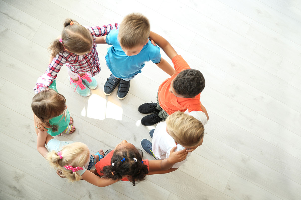 Little children making circle with hands around each other