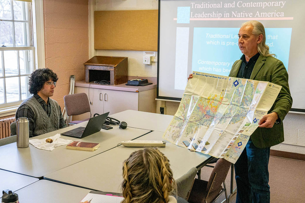 John Bear Mitchell shows a map titled "Maine's Ice Age Trail Down East" to his Teaching Wabanaki Studies class.