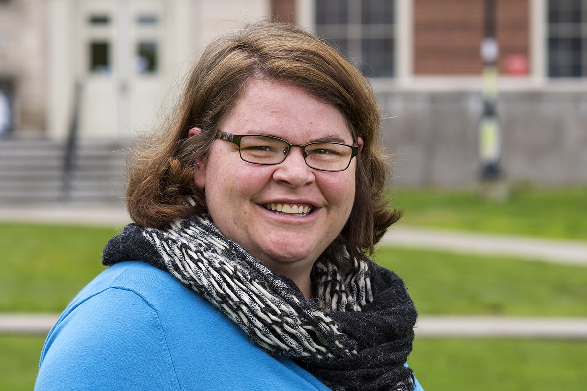 A photo of Catharine Biddle in front of Fogler Library on the University of Maine campus.