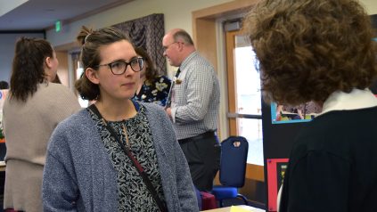 Natalie McCarthy, the 2023 outstanding graduating student in elementary education from the University of Maine College of Education and Human Development, talks to an employer at the college's 2023 education career fair.