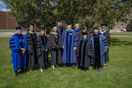 A group of College of Education and Human Development faculty in their regalia at commencement.