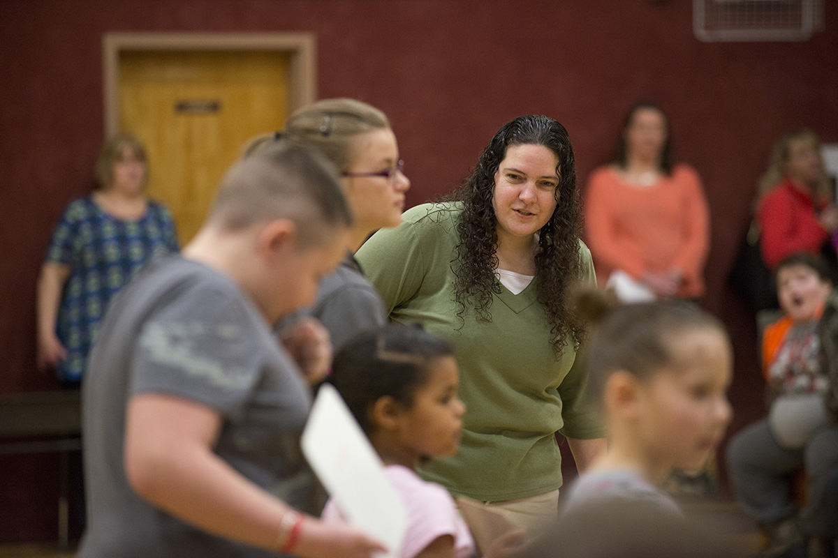 Linda Thomas, a teacher in Milbridge, Maine, works with students at a school-wide assembly.