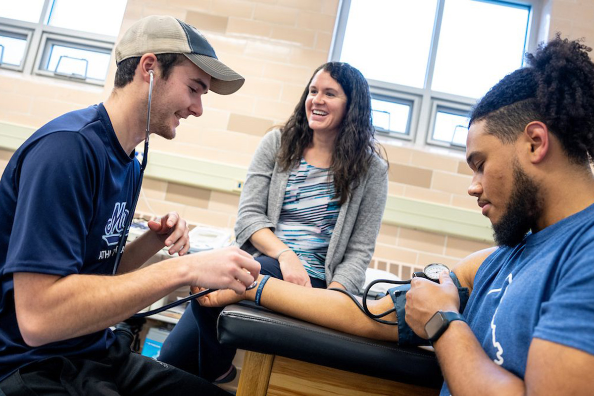 Assistant Professor of Athletic Training Alicia Lacy (middle) works with students at the Wes Jordan Athletic Training Education Complex on the University of Maine campus.