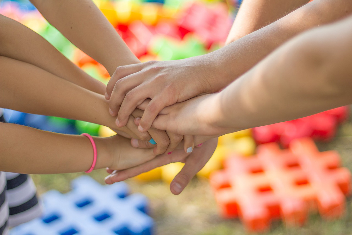 A photo of kids' hands touching in a circle.