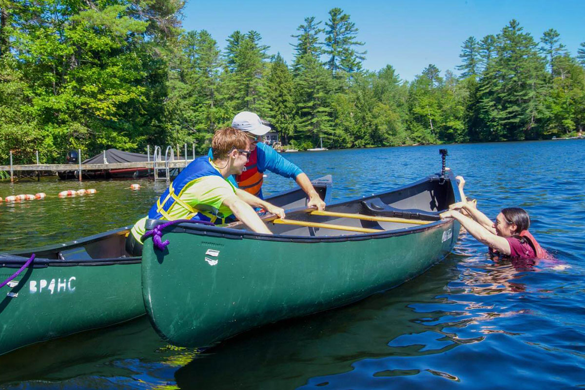 Students in canoes practicing a T-rescue at Bryant Pond as part of the “Bringing the Classroom Outdoors” course through the University of Maine.