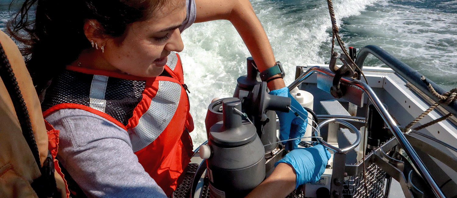 Student prepares niskin bottle on boat.