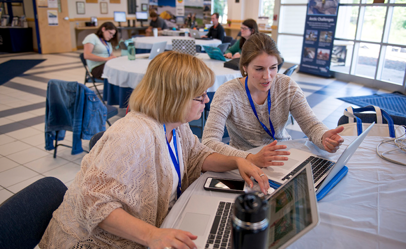 A photo of two women looking at a laptop