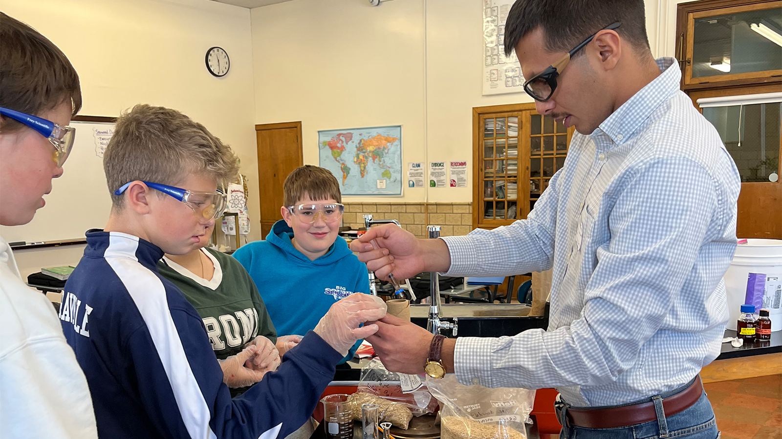 Ehsan works with students in a lab