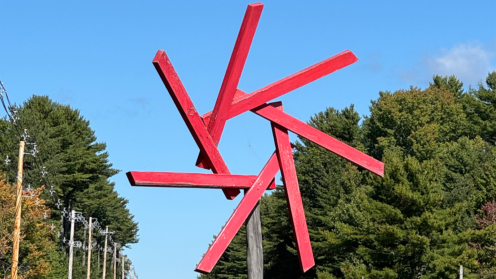7-pronged red pinwheel in front of forest background