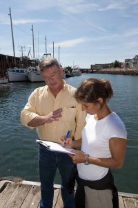 Researcher surveying local male stakeholder about Tidal Power on a dock in Eastern Maine