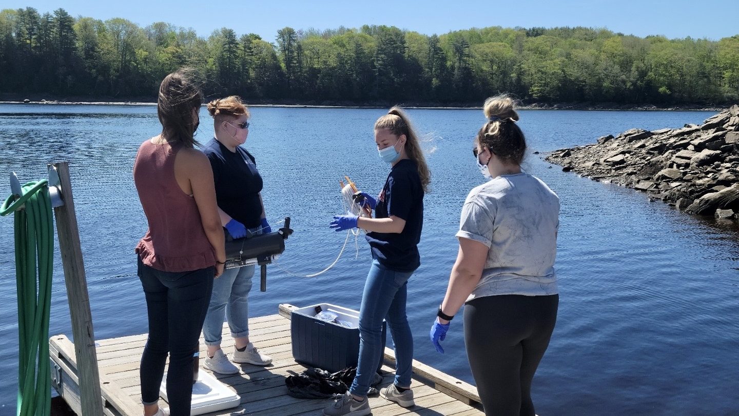 Photo of four individuals stand on dock practicing index sampling.