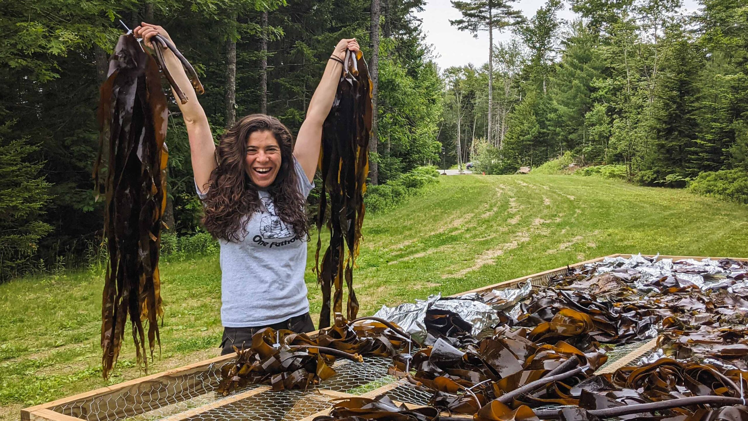 Rene Francolini holds seaweed above her head.