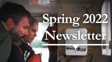 Photo of two individuals looking at computer screen on boat with text that reads Spring 2022 Newsletter