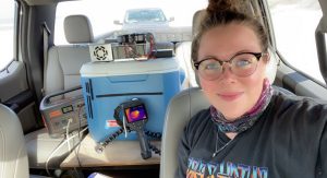 Roeder sits in car with thermal chamber she built using a cooler and electronics