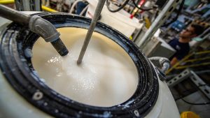 Vat of white liquid in lab space. 