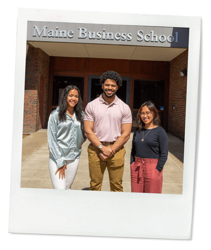 A photo of three business students standing in front of D.P. Corbett Business Building