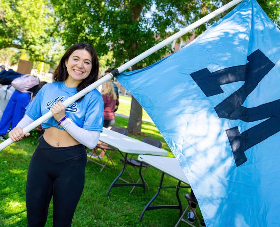 A photo of a student holding a large M flag