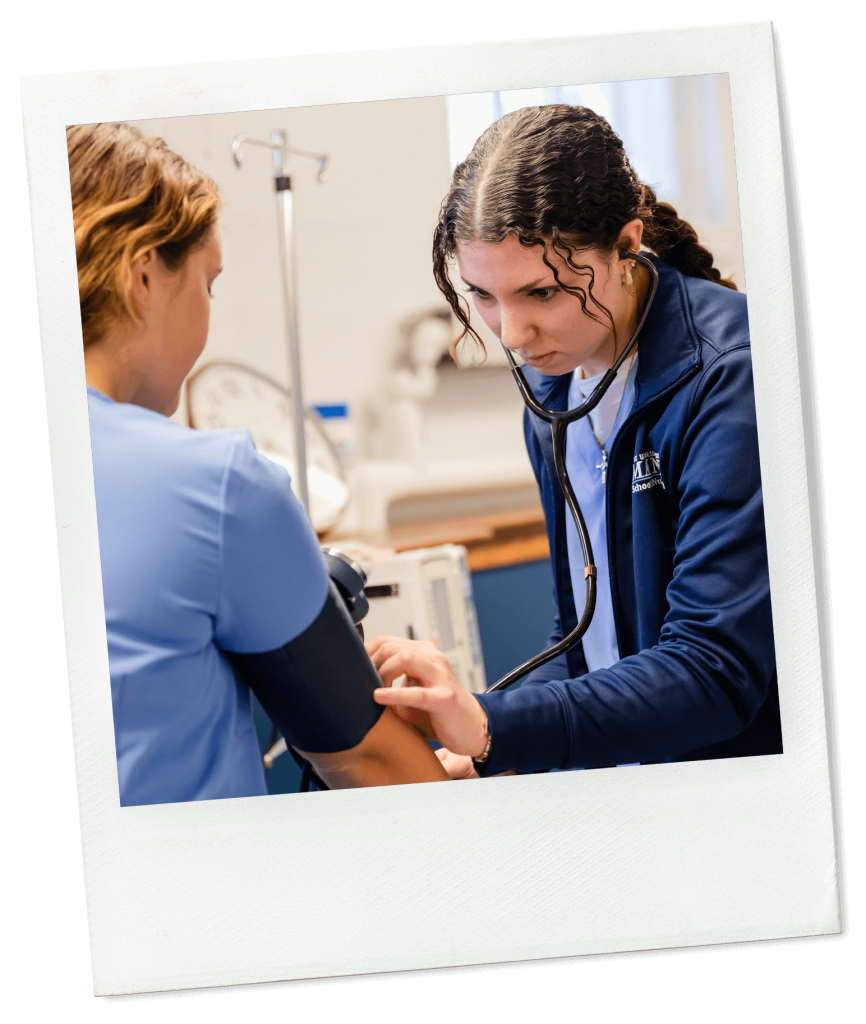 A photo of two nursing students working in a lab