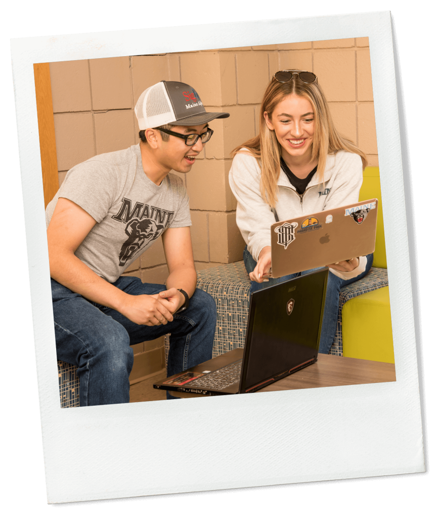 A photo of two business students looking at a laptop