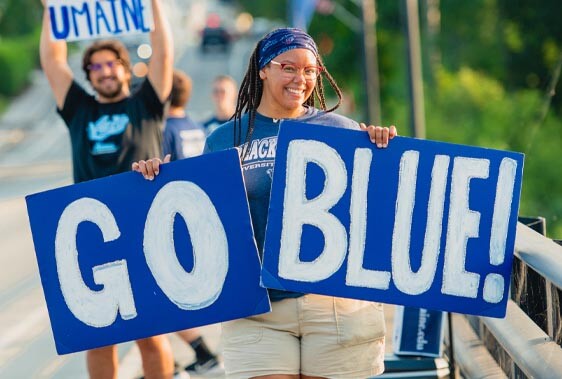 A photo of a person holding signs that read "Go" and "Blue"