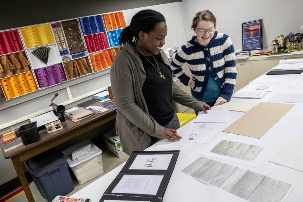 A photo of two people in a book arts class