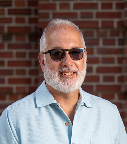 Portrait of William Nichols smiling and wearing sunglasses.