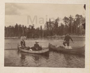 P00177 Men paddling loaded canoes.