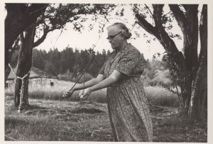 P0213: Elderly woman dowsing by slightly different method than Merrill; Mrs. J. Spurgeon Allaby, Passekeag, New Brunswick, July 1967.