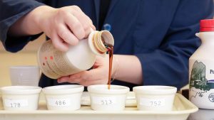 A photo of maple syrup being poured into a small cup