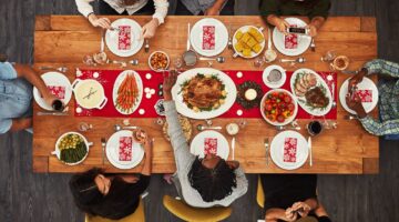 Photo of people sitting around a table, eating traditional holiday foods