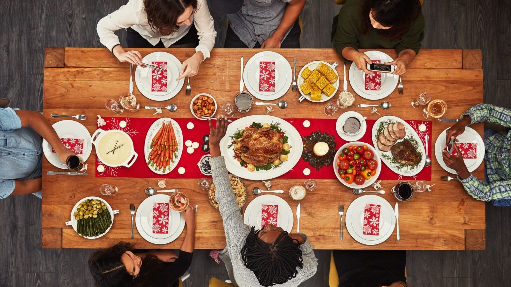 Photo of people sitting around a table, eating traditional holiday foods