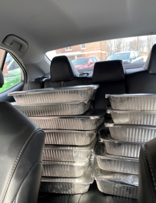 pictures of many tins of food in the back of a car in preparation for a food rescue