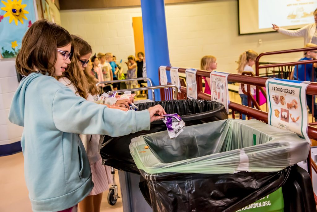 A student participates in sorting her food waste at Lisbon Community School.