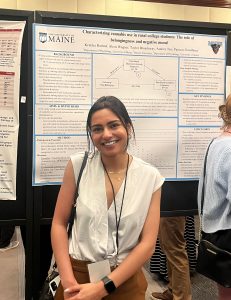 Katt stands in front of her research poster at RSMj 2023.