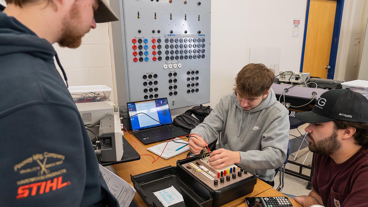 A photo of three students in an engineering lab