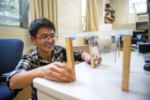 student building a small structure on desk