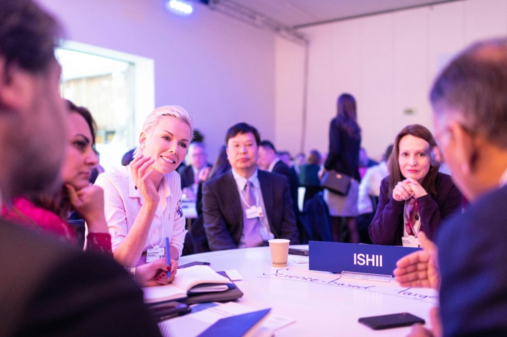 People sitting and talking at a round table in a conference room