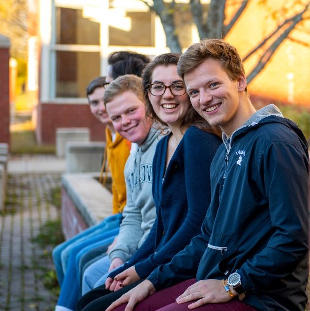 Smiling students sitting on campus