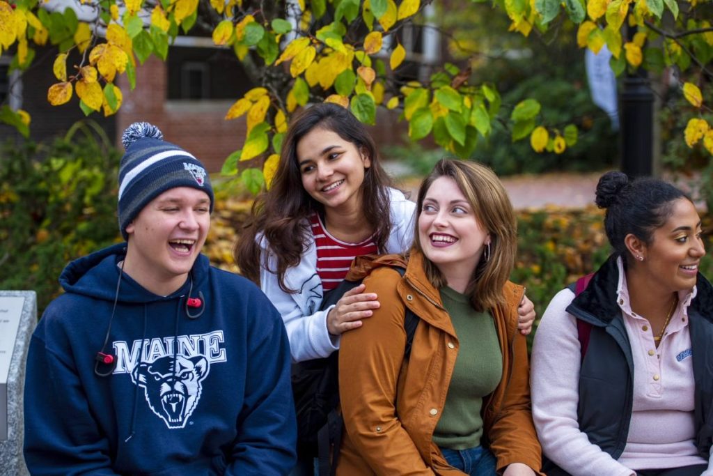 UMaine students smiling on campus