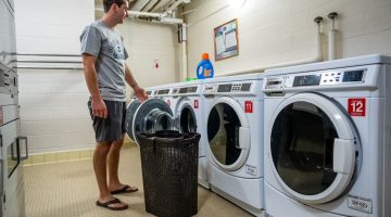 student doing laundry in residence hall