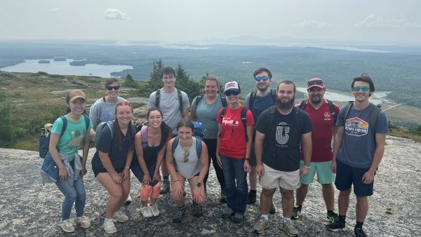 A group picture on top of Schoodic Mountain featuring the 2024 cohort of students.