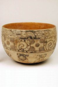 Off-white bowl, incised and painted with swirling designs.
