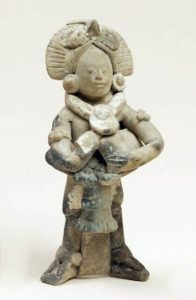 Intricately carved and sculpted figurine resembling a person pf elite status with an ornate headdress and jewelry  