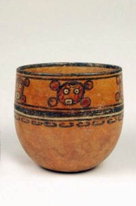 A round bottom vase with circular designs around the lip. These designs resemble faces.