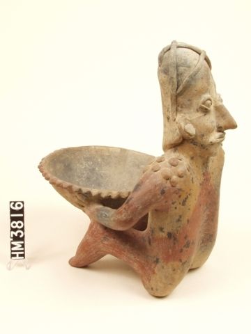 Seated ceramic figure, head facing backwards, holding bowl.