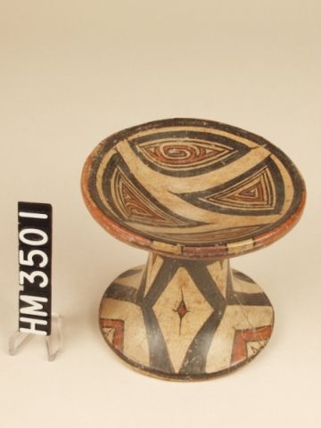 Cocle miniature polychrome ceramic pedestal plate. Macaracas type, Pica Pica variety. 
The shape possibly represents a flat-capped mushroom. "Y" element animal kennings adorn the four paneled sections. The sections are positioned in a manner suggesting the heads and tails of two "Y" shaped elements.