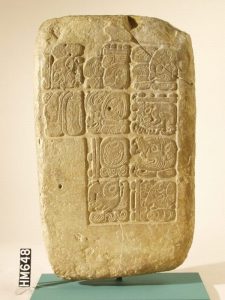 Maya glyphs carved into a slab of stone.