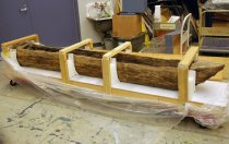Image of a dugout canoe in a protective storage frame. HM2544