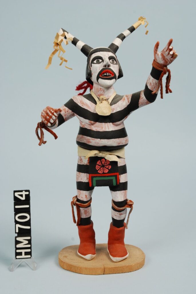 Image of small figure with black and white striped clothing and colorful decoration.